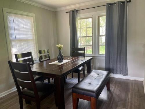 a dining room table with chairs and a vase on it at New Modern Lux Large Home 10MIN Downtown Sleeps 12 in Taylors