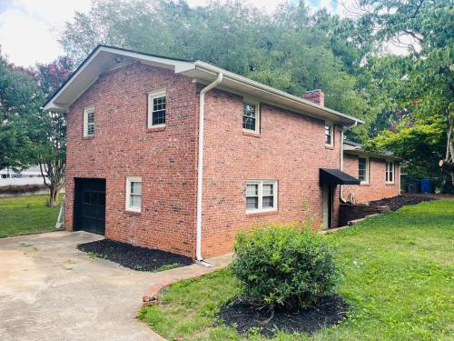 a brick house with a garage in a yard at New Modern Lux Large Home 10MIN Downtown Sleeps 12 in Taylors
