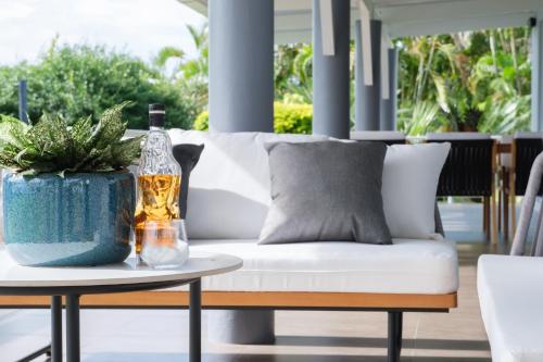 a white couch with a bottle on a table at Luxury Hilltop Dual Villas With Stunning Sea Views & Pools ! in Lauwaki