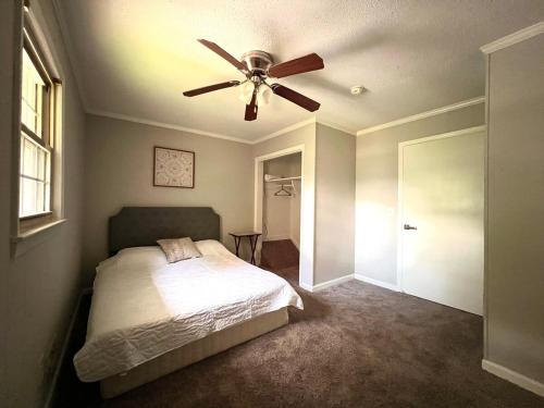 a bedroom with a bed and a ceiling fan at New Modern Lux Large Home 10MIN Downtown Sleeps 12 in Taylors