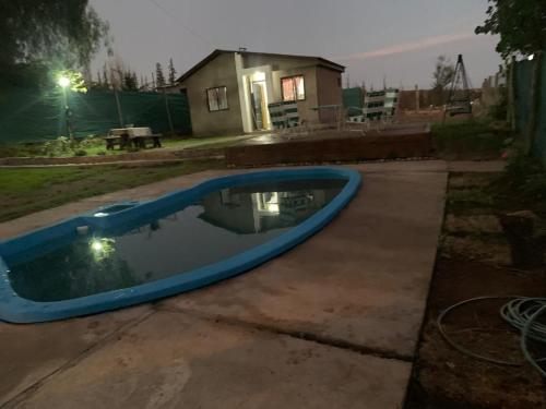 a blue swimming pool in a yard at night at Cabaña la Morocha in Ciudad Lujan de Cuyo