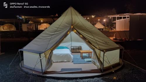 a tent with a bed and a table in it at ฤดูกาลเขาค้อ in Khao Kho