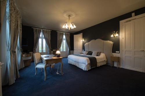 a bedroom with a bed and a table and a chair at Chateau du Clos de la Ribaudiere - Teritoria in Chasseneuil-du-Poitou