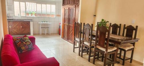 a living room with a table and a red couch at Casa Chico Rei in Ouro Preto
