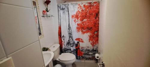 ein Badezimmer mit Duschvorhang und einer Frau mit Regenschirm in der Unterkunft Departamento a pasos del Faro in La Serena