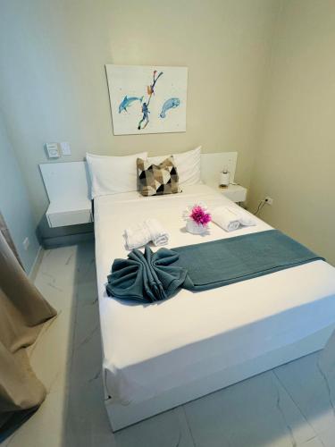 a bedroom with a bed with white sheets and flowers on it at Sundown Relaxed in Punta Rucia