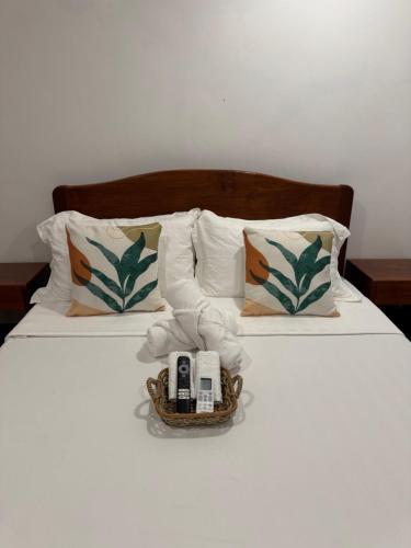 un letto con due telefoni e un cesto sopra di Surf House Palawan a San Vicente