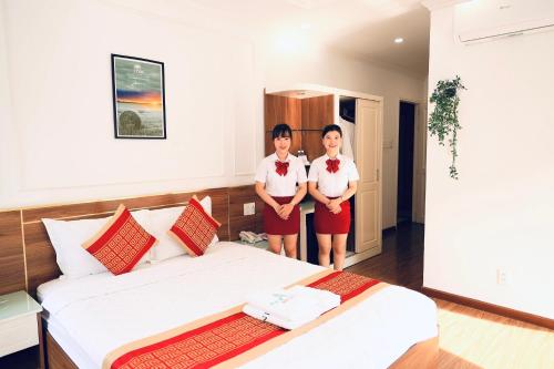 two women standing in a hotel room with a bed at NEW CITY HOTEL in Tây Ninh