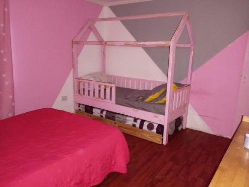 a pink bedroom with a bed and a pink room at La casa naranja de Amaia in Sierra Grande