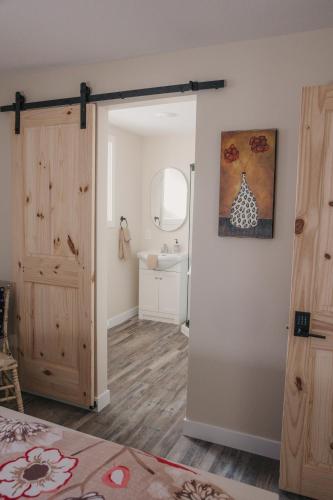 a bedroom with a door open to a bathroom at Old Stone Inn in Estevan