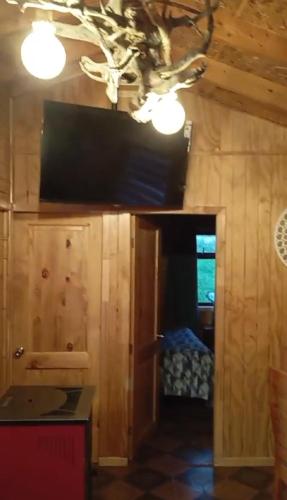 a kitchen with wooden walls and a room with a window at Patagon karim in Puerto Cahacabuco
