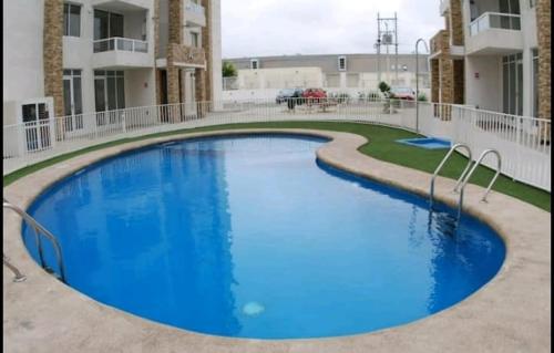 ein großer blauer Swimmingpool vor einem Gebäude in der Unterkunft Departamento a pasos del Faro in La Serena