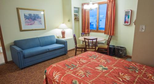 a hotel room with a bed and a couch and a table at Calypso Boutique Hotel in Wildwood