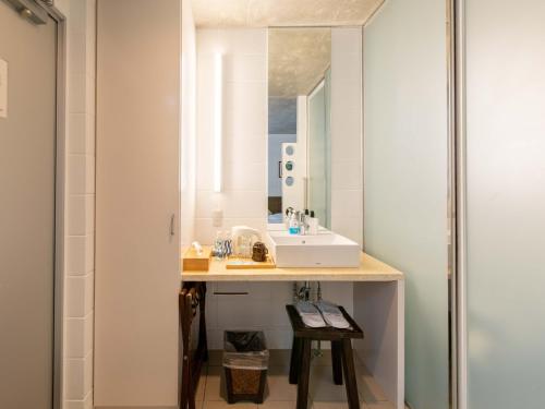 a bathroom with a sink and a mirror at 413 Hamahiga Hotel＆Cafe in Uruma