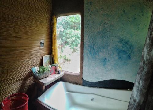 ein Badezimmer mit Badewanne und Fenster in der Unterkunft Casa Kawsay Punta N in Barra de Portezuelo