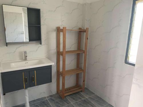 une salle de bain avec un lavabo et une étagère en bois dans l'établissement Wild Wood x Hansa Beach Fitness Resort, à Thongsala