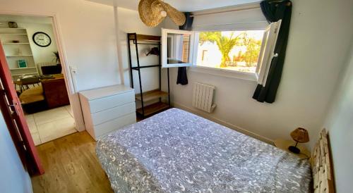 une petite chambre avec un lit et une fenêtre dans l'établissement Sewa surf House 10min Capbreton 1, à Bénesse-Maremne