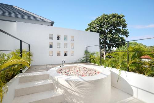 a hot tub on the balcony of a house at Villa Sugi Umalas in Canggu