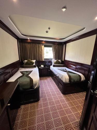 a hotel room with two beds and a table at فندق ريفر المعادي in Cairo
