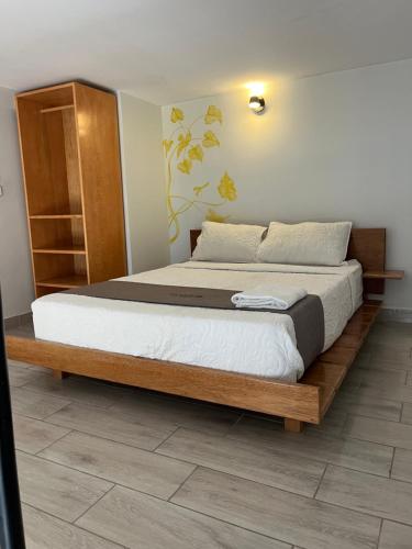 a bedroom with a large bed with a wooden frame at Mi Quinta Raíz Loft Apartments in Iquitos
