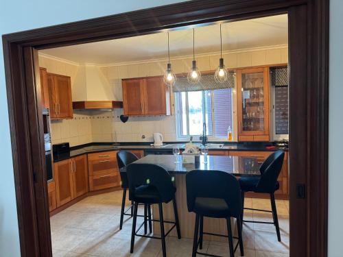 a kitchen with a table and chairs in it at Populo Beach Villa, Walk to Beach, Air Conditioning and Heating, near Ponta Delgada in Livramento