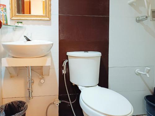 a bathroom with a toilet and a sink at Hotel Elinas and Restaurant in Tuguegarao City