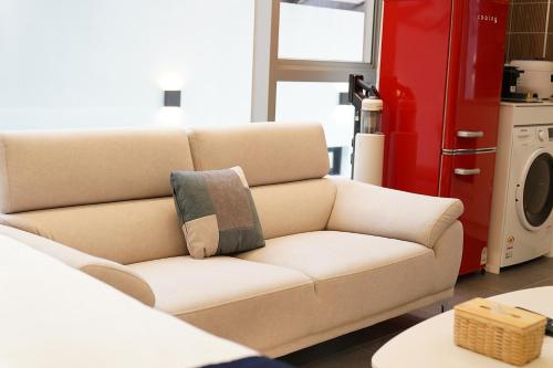 a living room with a white couch and a red refrigerator at Gyeongju Poolvilla Runtoyou in Gyeongju