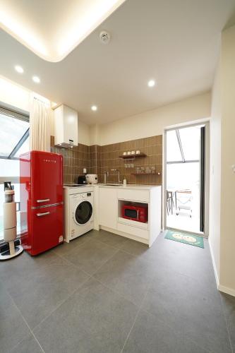 a kitchen with a red refrigerator and a washing machine at Gyeongju Poolvilla Runtoyou in Gyeongju