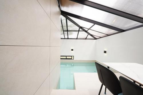 a room with a pool and a table and chairs at Gyeongju Poolvilla Runtoyou in Gyeongju