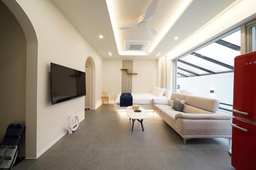 a living room with a couch and a tv at Gyeongju Poolvilla Runtoyou in Gyeongju