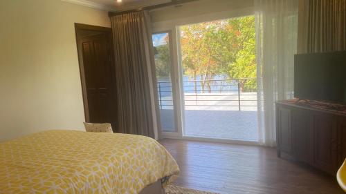 a bedroom with a bed and a sliding glass door at CASA DEL LAGO in Cachí