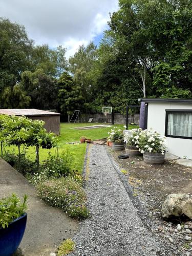 a garden with potted plants in a yard at Whare iti on Johns in Christchurch