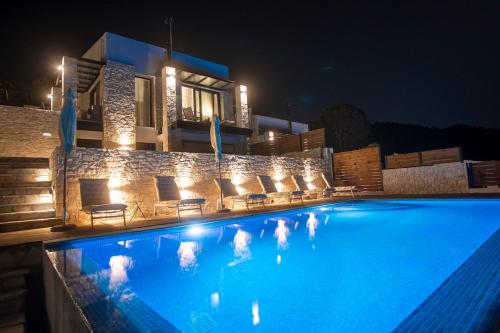 a swimming pool with chairs and a house at night at Allure Luxury Villas 2, Skiathos in Skiathos Town