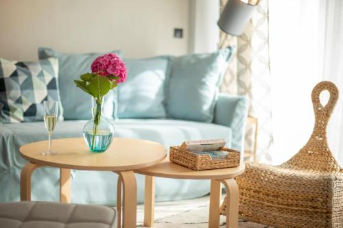 a living room with a couch and a table with a vase with a flower at Allure Luxury Villas 2, Skiathos in Skiathos Town