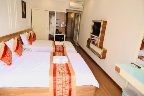 a hotel room with two beds and a television at NEW CITY HOTEL in Tây Ninh