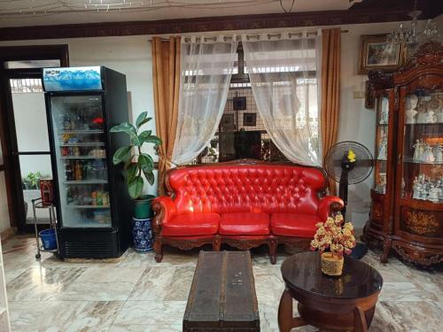 a living room with a red couch and a table at Hotel Elinas and Restaurant in Tuguegarao City