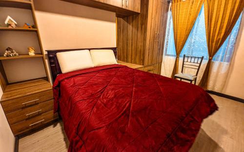 a bedroom with a red bed and a window at Confort en el Centro de Cuenca in Cuenca