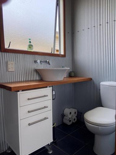 a bathroom with a sink and a toilet at Ōtaki Beach Gem - Coastal Family Getaway in Otaki Beach