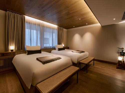 a bedroom with two beds and a window at Glamdy style hotel suite 山ノ麓 in Karuizawa