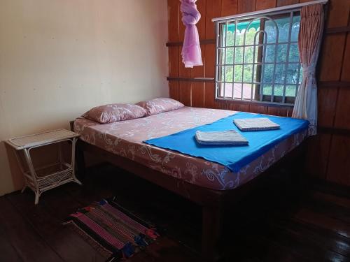 a bed in a room with a window at Sophea's guesthouse in Kaôh Kon