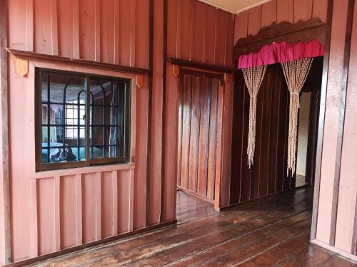 an empty room with red walls and a window at Sophea's guesthouse in Kaôh Kon