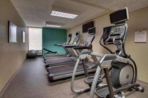 a gym with rows of treadmills and phones at Heritage Inn & Suites The Woodlands, Trademark by Wyndham in The Woodlands