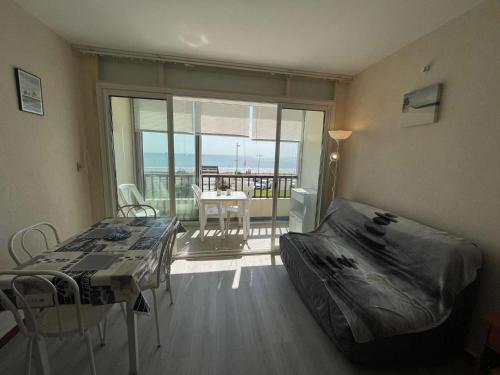 - une chambre avec un lit, une table et un balcon dans l'établissement Studio en bord de mer avec balcon et parking - FR-1-224C-334, à Saint-Jean-de-Monts
