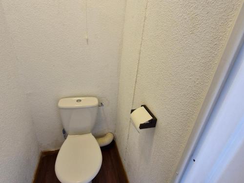 une salle de bain avec des toilettes et un rouleau de papier toilette dans l'établissement Appartement spacieux avec terrasse et garage, accès piscine - FR-1-814-88, à Besse-et-Saint-Anastaise