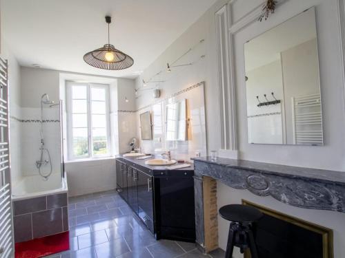 une salle de bain avec deux lavabos et un grand miroir dans l'établissement Grande maison avec piscine naturelle et jardin en Dordogne - FR-1-616-463, à Pomport