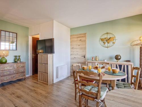 une salle à manger avec une table et une télévision dans l'établissement Appartement élégant avec balcon vue mer et parking sécurisé à Cabourg - FR-1-788-50, à Cabourg