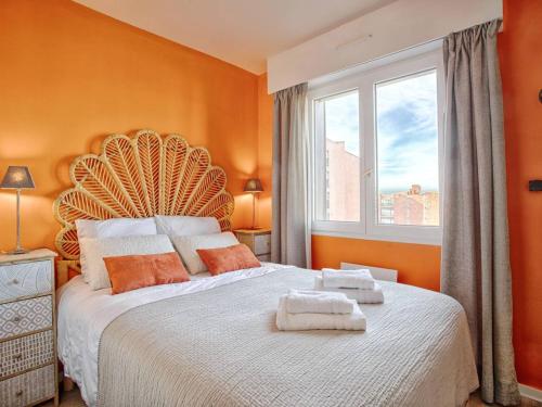 - une chambre avec un grand lit aux murs orange et une fenêtre dans l'établissement Appartement élégant avec balcon vue mer et parking sécurisé à Cabourg - FR-1-788-50, à Cabourg