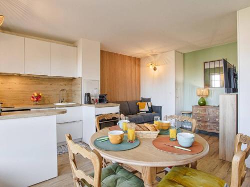 une cuisine et une salle à manger avec une table dans une pièce dans l'établissement Appartement élégant avec balcon vue mer et parking sécurisé à Cabourg - FR-1-788-50, à Cabourg