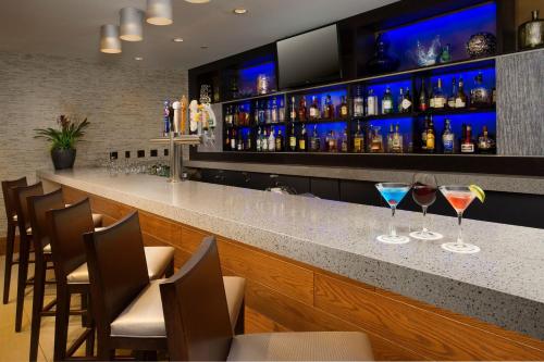 a bar with two wine glasses on a counter at Skybridge Seattle Airport Hotel in Seattle