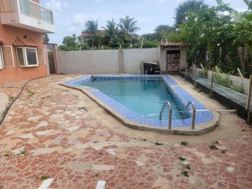 a swimming pool in a yard next to a house at Casa Del Mar Apartments in Brufut